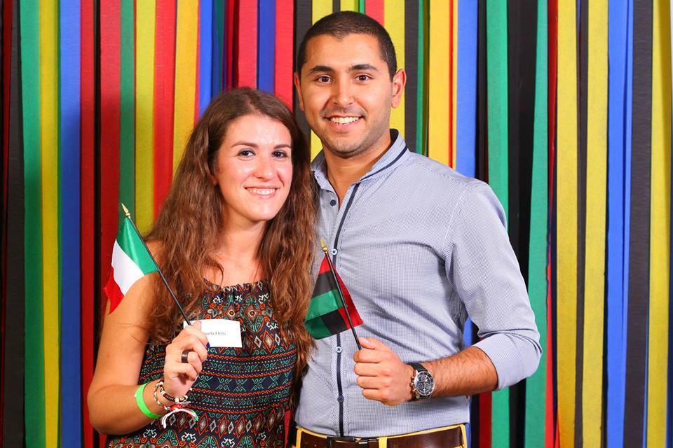 Man and woman smiling holding an Italy and Libya flag